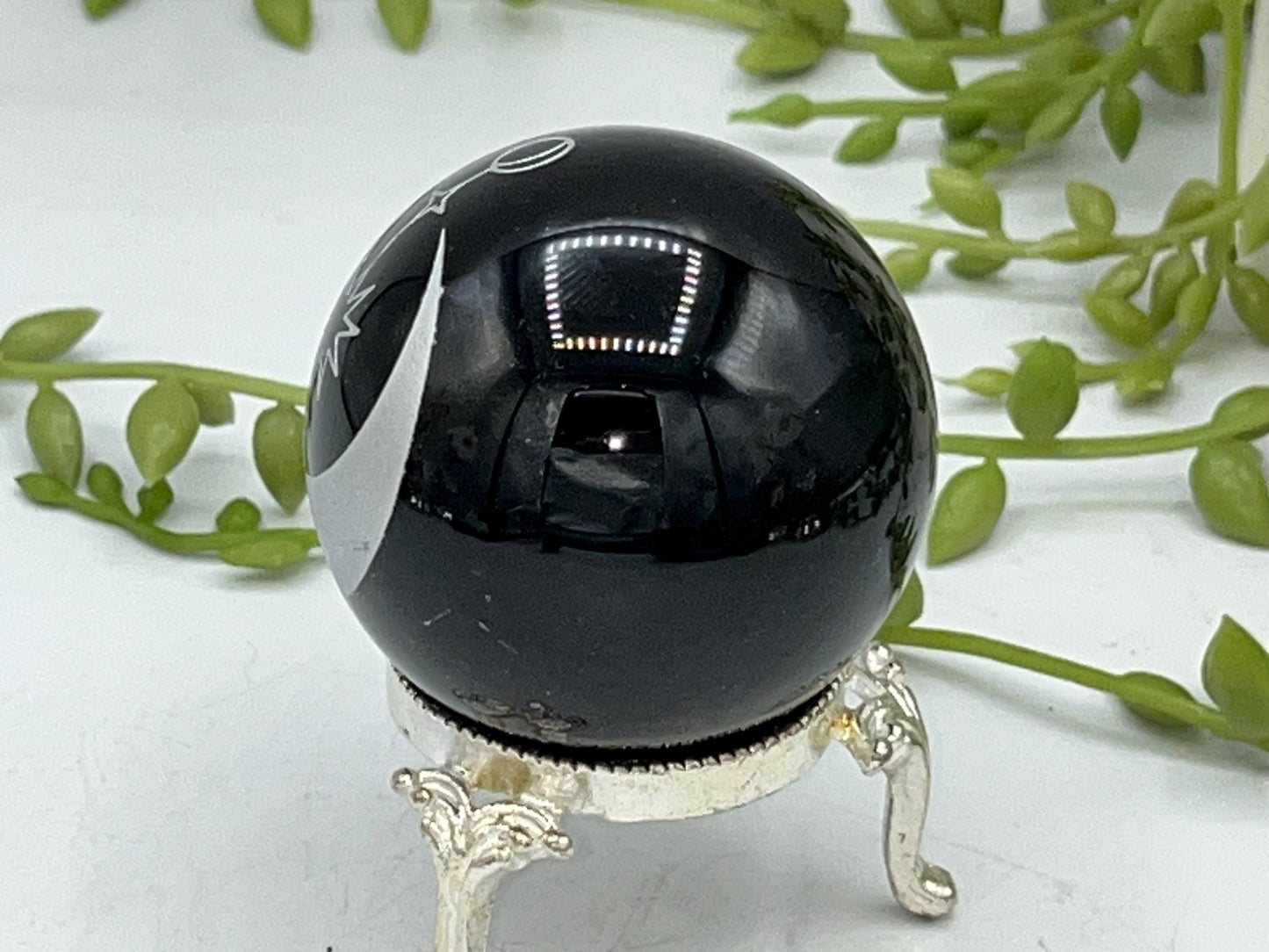 Black obsidian sphere with a moon and star celestial style pattern engraved in silver. crystal spheres, home decor, crystal healing, gift